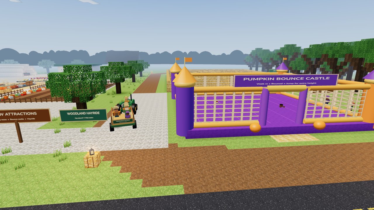 Inside Moonlight Patch: families on the tractor hayride beside the purple and gold bounce castle, with the large hay maze beyond